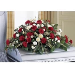 Red and white floral casket spray on a white casket
