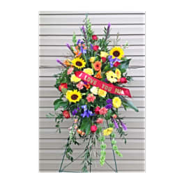 Standing floral spray with sunflowers, roses, and a red ribbon reading I LOVE YOU PAPA