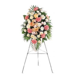 Standing floral spray with pink, white, and peach flowers on an easel