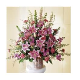 Pink lilies and mixed flowers in a woven vase