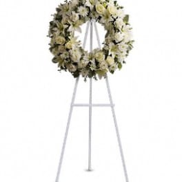 White floral funeral wreath on a standing easel