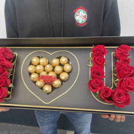 Black gift tray with red roses and Ferrero Rocher chocolates arranged as LOVE