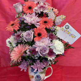 Lavender and pink mixed bouquet in a floral mug vase with butterfly accents