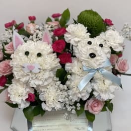 Bouquet of white and pink flowers arranged as two bunny faces in a mirrored box
