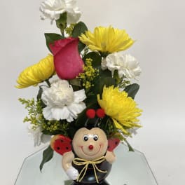 Bouquet with yellow and white flowers in a ladybug figurine vase