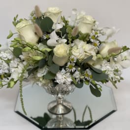 White floral arrangement in a silver pedestal vase