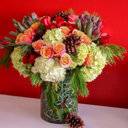 Bouquet of roses and hydrangeas in a holiday vase with pinecones