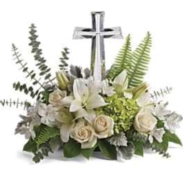 White floral arrangement with a silver cross centerpiece