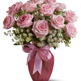 Pink roses arranged in a vase with a satin ribbon