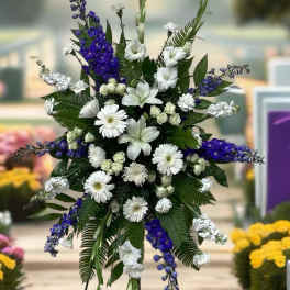 Standing floral spray with white and purple flowers on a metal easel