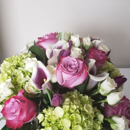 Bouquet of pink roses, white calla lilies, and green hydrangeas
