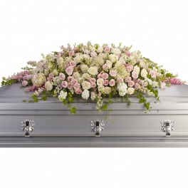 Pastel rose casket spray with white flowers on a silver casket