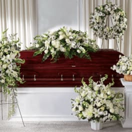 White floral funeral arrangements around a casket
