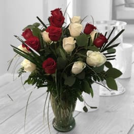 Red and white roses arranged in a glass vase