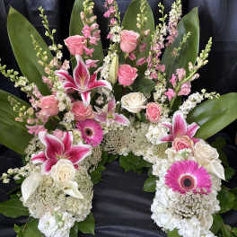 Pink and white floral funeral spray with lilies, roses, and gerbera daisies