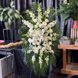 Tall white floral standing spray with lilies and roses