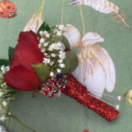 Red rose boutonniere with baby's breath and a glittery red handle
