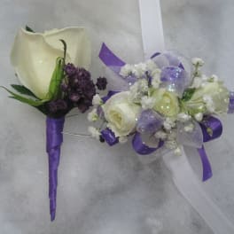 Two floral boutonnieres with white roses and purple accents