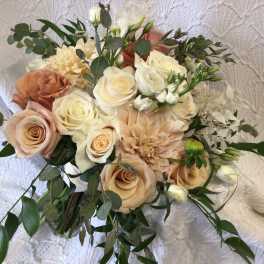 Bouquet of cream and peach roses with greenery