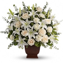 White lilies and cream roses arranged in a brown urn vase
