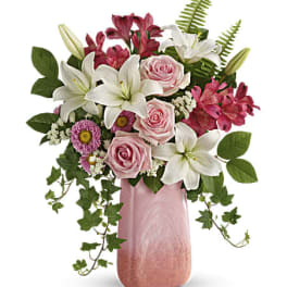Pink and white floral arrangement in a tall pink vase