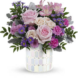 Pink roses and purple flowers in a patterned vase