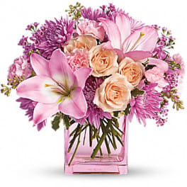 Pink and peach bouquet in a square glass vase