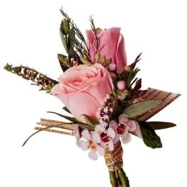 Pink rose boutonniere with small accent flowers and greenery