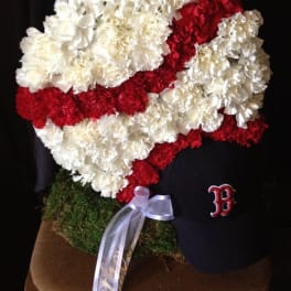 Red and white carnation arrangement shaped like a baseball cap