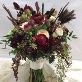 Bouquet of burgundy, cream, and pink flowers with dried accents