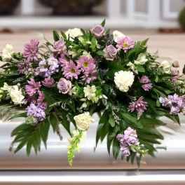 Lavender and white floral casket spray with greenery