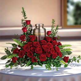 Red rose centerpiece around a silver urn on a table