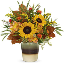 Sunflowers and autumn flowers arranged in a ceramic vase