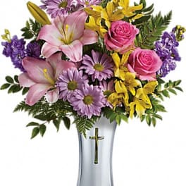 Bouquet of pink lilies, roses, and purple daisies in a silver vase