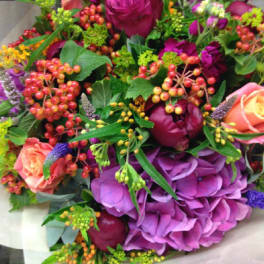 Bouquet of pink and purple flowers with berry accents
