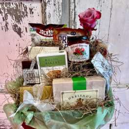 Gift basket with assorted packaged foods and a pink rose