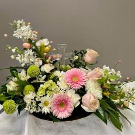 Pastel floral arrangement with a clear cross centerpiece