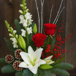 Holiday arrangement with red roses, white lilies, and pinecones in a wooden box