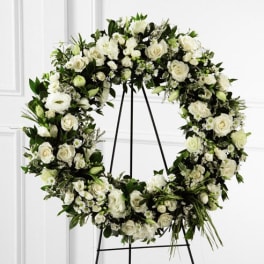 Large white floral wreath on a black stand