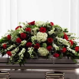 Red and white floral casket spray on a silver casket