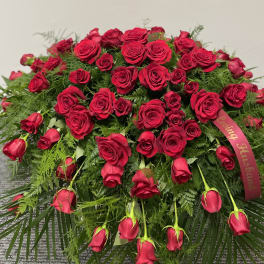 Large red rose arrangement with a ribbon and trailing roses
