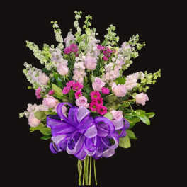 Bouquet of pink and lavender flowers with a purple ribbon bow