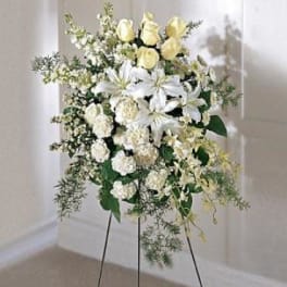 White and pale yellow floral standing spray on a black easel