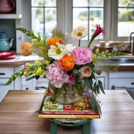 Mixed bouquet in a glass vase with orange, pink, and white blooms