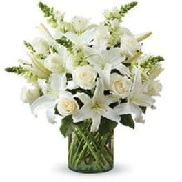 White lilies and roses arranged in a glass vase