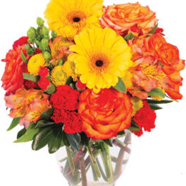 Bouquet of yellow gerbera daisies and orange roses in a clear glass vase