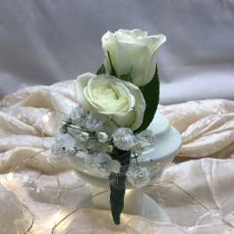 Two white roses with baby's breath in a small holder