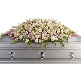 White and pink floral casket spray on a silver casket