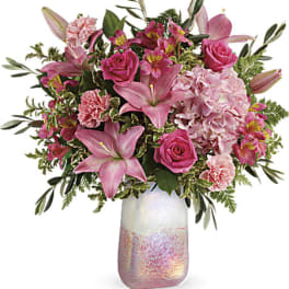Pink roses and lilies arranged in a iridescent vase
