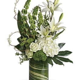 White lilies and roses arranged in a green glass vase